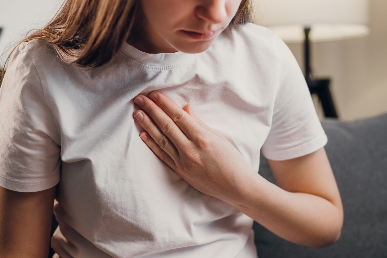 woman grabbing her chest with anxiety.